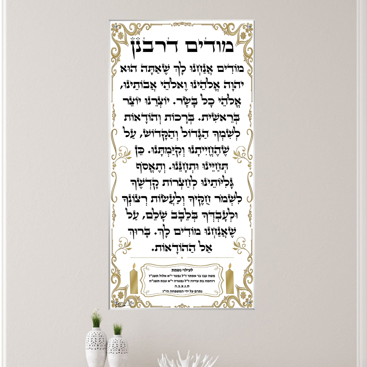 תמונת זכוכית של מודים דרבנן במסגרת זהובה, עם הקדשה לעילוי נשמה, תלויה על קיר בית כנסת בעיצוב מודרני.