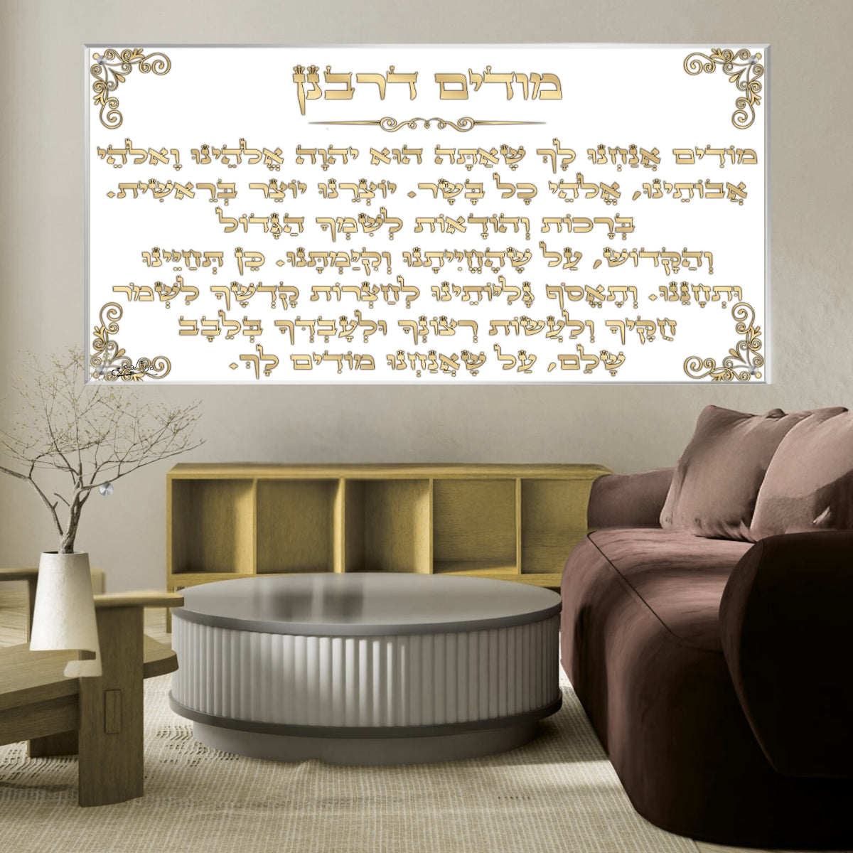 תמונת זכוכית של מודים דרבנן עם טקסט זהוב על רקע לבן, תלויה מעל ספה מודרנית בעיצוב חמים.