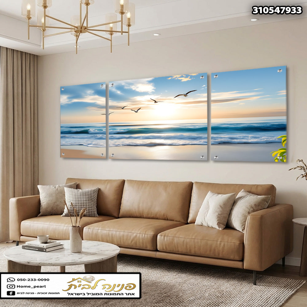 תמונת חוף ים בשקיעה מחולקת לשלושה חלקים מעל ספה בסלון - הדפסה על זכוכית